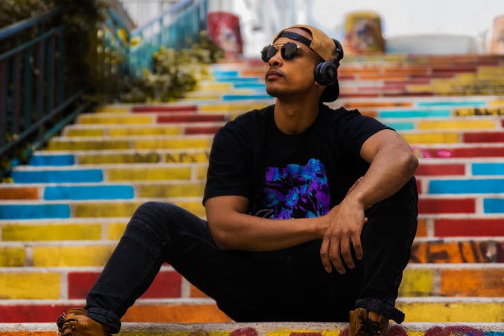 man with headphones on sitting on steps